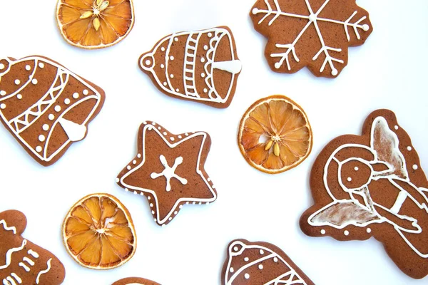 おいしい自家製クリスマスジンジャーブレッドクッキー様々な形の砂糖釉と白の背景に乾燥レモンのスライス — ストック写真