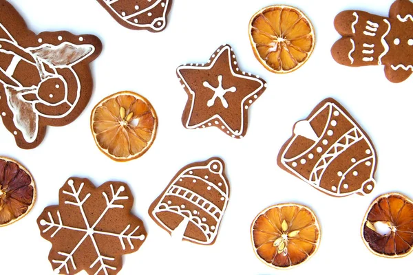 おいしい自家製クリスマスジンジャーブレッドクッキー様々な形の砂糖釉と白の背景に乾燥レモンのスライス — ストック写真