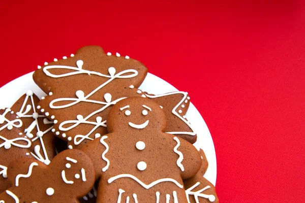 おいしい自家製クリスマスジンジャーブレッドクッキーコピースペースと明るい赤の背景に砂糖釉と様々な形のクッキー 閉じろ — ストック写真