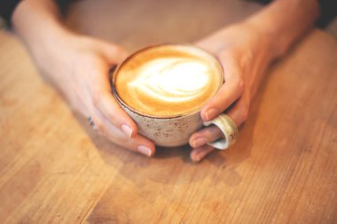 Bir fincan kahve tutan kız.