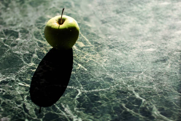 Manzana verde sobre una mesa de mármol — Foto de Stock