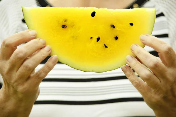 Yellow watermelon in hand