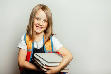 Okul için hazırlanan ders kitapları ve sırt çantalı çocuk