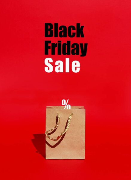 paper bag for purchases on red background with text. Black Friday pattern concept