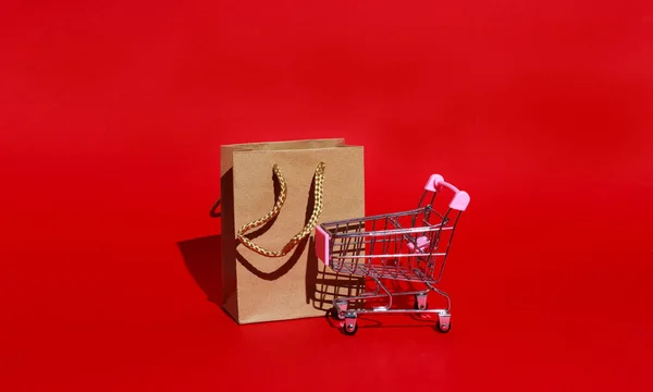 Warenkorb Und Papiertüte Für Einkäufe Auf Rotem Hintergrund Mit Platz — Stockfoto