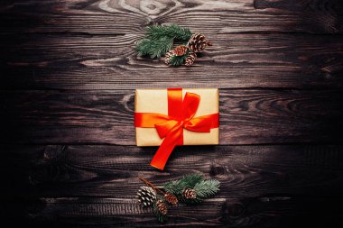 Kırmızı kurdeleli ve ağaç dallı yeni yıl hediyesi kutusu.