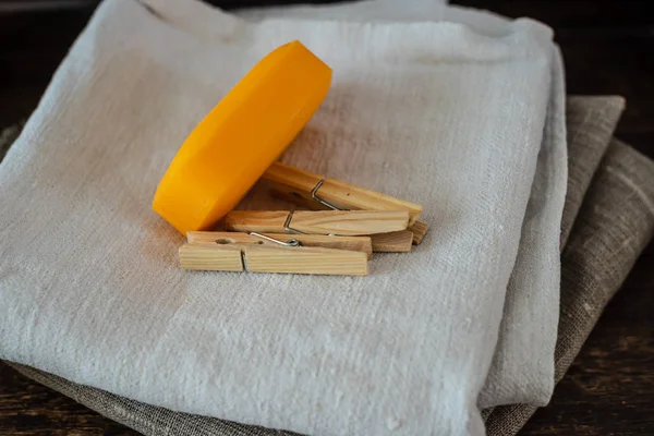 Stack of clean linen towels, clothespins and natural soap on table
