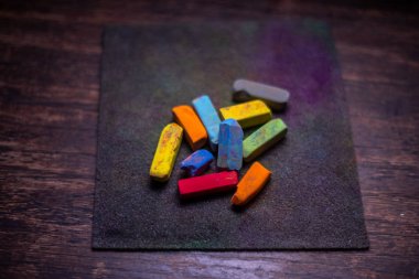 Eski ahşap yüzey üzerinde çizim için renkli pastel boya kalemleri.