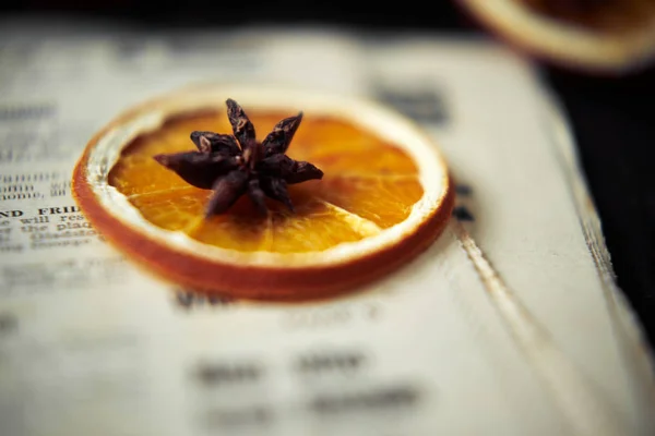 Soft focus background with orange and star anise on the top on vintage newspaper. Close up