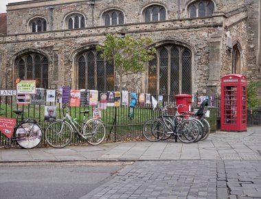 Cambridge, Uk - 9 Ekim 2019: Bir sürü posterle birlikte çitin karşısına park edilmiş bisikletler