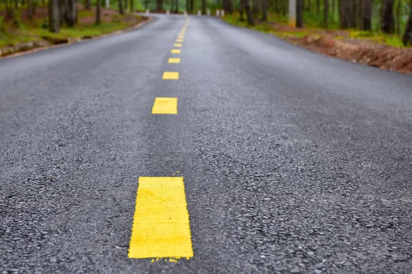 Asphalt road with yellow line marking on road surface for separate lanes