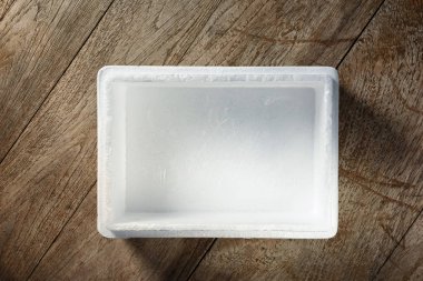 Ahşap arka plan üzerinde boş açık soğuk köpük kutusunun üstten görünüm