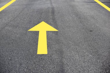 Asfalt yol yüzeyindeki sarı ok, ulaşım konsepti ve hareket etmeye devam et