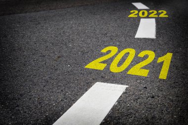 Yeni yılı 2021 'den 2022' ye kadar kapatıyoruz. Siyah asfalt yolda ve beyaz işaret çizgilerinde, başarıya giden yolda yeni yılınız kutlu olsun.
