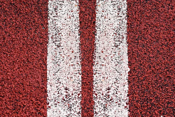 Two white lines marking on red sport track background
