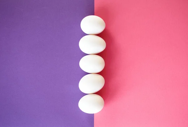Pasen witte eieren op de achtergrond van een paars-roze. — Stockfoto