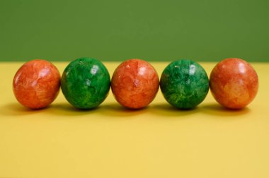 Sarı ve yeşil arka planda Paskalya yumurtaları.