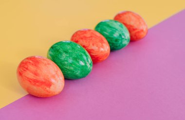 Sarı ve mor arka planda Paskalya yumurtaları.