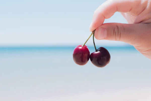 Две вишневые ягоды в руке . — стоковое фото
