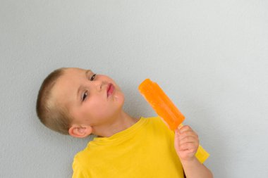 Elinde dondurma tutan küçük bir çocuk..