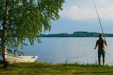Gölün kıyısında balık avlatan adam..