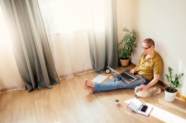 Genç adam evde çalışıyor..