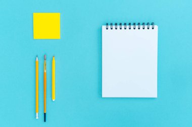 Spiral, ofis ve mavi arka planda okul malzemeleri üzerine boş bir not defteri aç. Uzayı kopyala, düz yat. Okul konseptine dönelim..