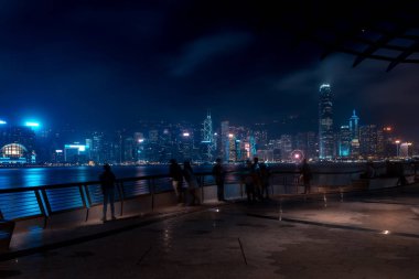 Hong Kong cityscape geceleri. Rıhtımlar üzerinde yürüyen turist