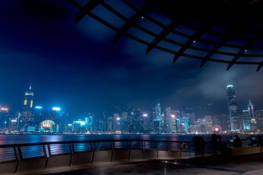 Hong Kong cityscape geceleri. Rıhtımlar üzerinde yürüyen turist