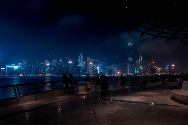 Hong Kong városkép éjjel. Séta a vízparton, a turisták — Stock Fotó