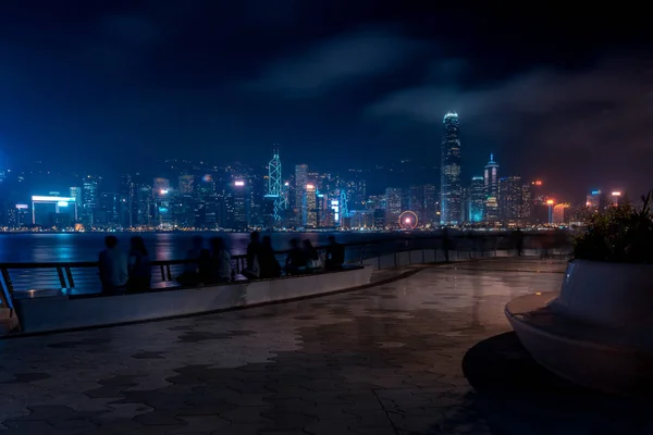 Hong Kong stadsbild nattetid. Turister promenader vid vattnet — Stockfoto