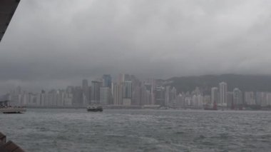 Hong Kong, Çin, 12 Nisan 2019 : Yağmur gününde Victoria Harbor ve Hong Kong Adası Skyline yavaş hareket. Hong Kong en yoğun nüfuslu şehir biridir.