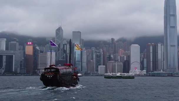 香港、中国、2019年4月12日:雨の日にビクトリア港を横断する有名なツアージャンク船「アクアルナ」のスローモーション — ストック動画