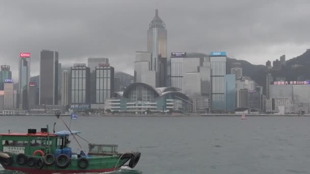 Hong Kong, Çin, 12 Nisan 2019 : Yağmur gününde Victoria Harbor ve Hong Kong Adası Skyline yavaş hareket. Hong Kong en yoğun nüfuslu şehir biridir. — Stok video