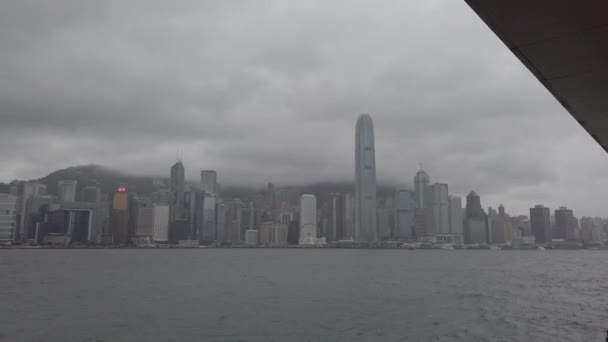 Hong Kong, China, 12 de abril de 2019: cámara lenta de Victoria Harbor y Hong Kong Island Skyline en el día de lluvia. Hong Kong es una de las ciudades más densamente pobladas . — Vídeo de stock