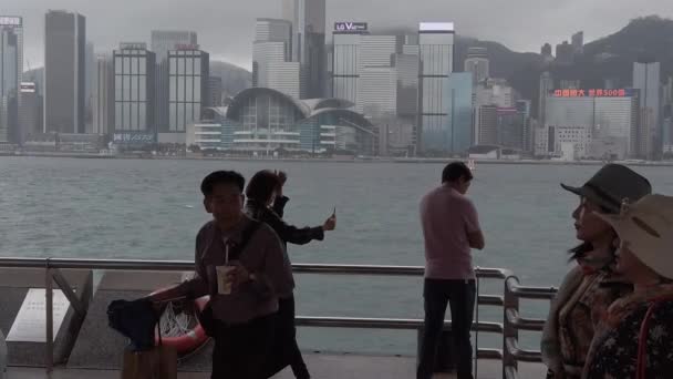 Hong Kong, China, 12 de abril de 2019: Slow Motion of Tourists visiting the waterfront in Tsim Sha Tsui at rain day- es un famoso destino turístico . — Vídeos de Stock