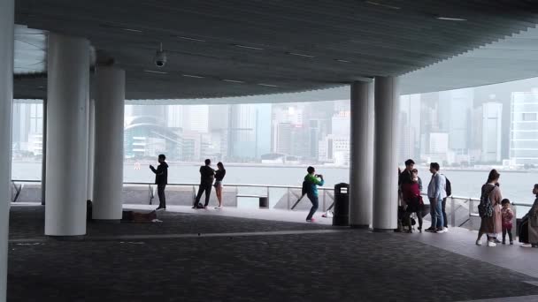 Χονγκ Κονγκ, Κίνα, 12 Απριλίου, 2019: η αργή κίνηση των τουριστών που επισκέπτονται την προκυμαία στο Τσιμ Σα Τσούι την ημέρα της βρέχει-είναι ένας διάσημος τουριστικός προορισμός. — Αρχείο Βίντεο