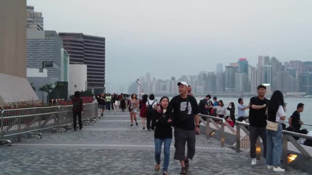 Movimiento lento de turistas que visitan el paseo marítimo en Tsim Sha Tsui — Vídeos de Stock