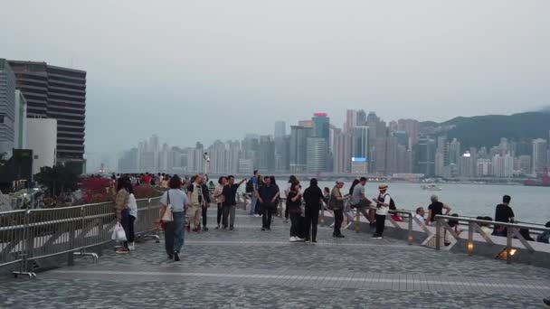 Movimiento lento de turistas que visitan el paseo marítimo en Tsim Sha Tsui — Vídeos de Stock