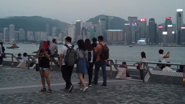 Movimento lento de turistas que visitam a orla marítima em Tsim Sha Tsui — Vídeo de Stock