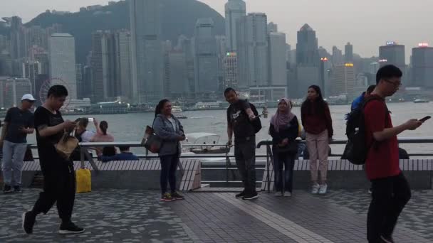 Movimiento lento de turistas que visitan el paseo marítimo en Tsim Sha Tsui — Vídeo de stock