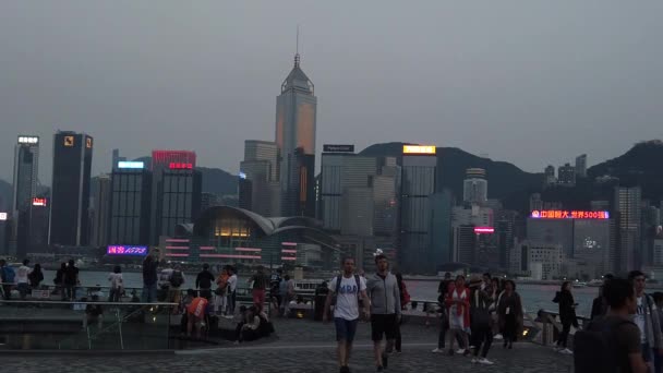 Movimiento lento de turistas que visitan el paseo marítimo en Tsim Sha Tsui — Vídeos de Stock