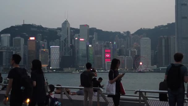 Movimiento lento de turistas que visitan el paseo marítimo en Tsim Sha Tsui — Vídeos de Stock