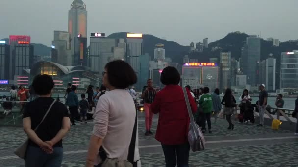 Movimiento lento de turistas que visitan el paseo marítimo en Tsim Sha Tsui — Vídeos de Stock