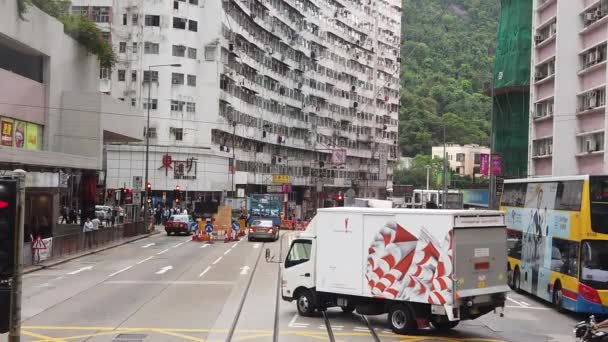 Медленное движение при просмотре уличной сцены Гонконга с трамвайного пути с двойным деккером . — стоковое видео