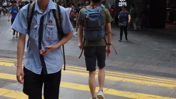 Movimento lento de pedestres caminhando ao longo da estrada movimentada — Vídeo de Stock