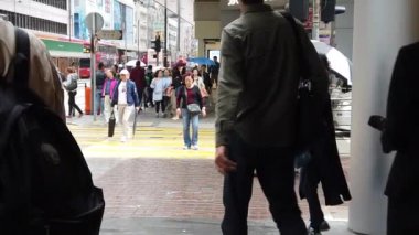 Asya yerlive turistler yağmur gününde centra bir yaya köprüsü geçerken
