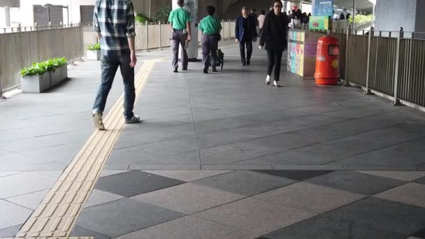 Les habitants asiatiques et les touristes traversant une passerelle piétonne à centra le jour de la pluie — Video