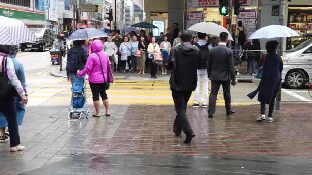 Asian locals and tourists crossing a pedestrian bridge in centra at raining day — Stock Video