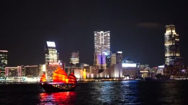 Hong Kong City gece görünümü kırmızı yelken önemsiz tekneler ile. 